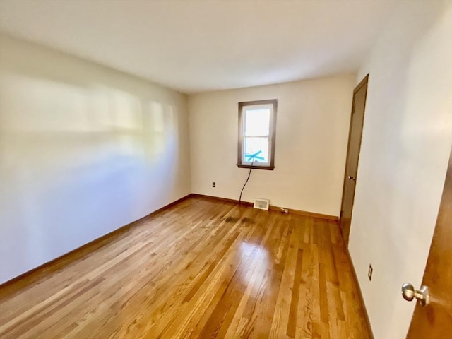 unfurnished room with baseboards and light wood-style flooring