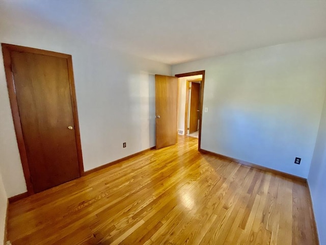 spare room with light wood-type flooring and baseboards