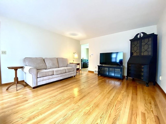 living area featuring light wood-style floors and baseboards