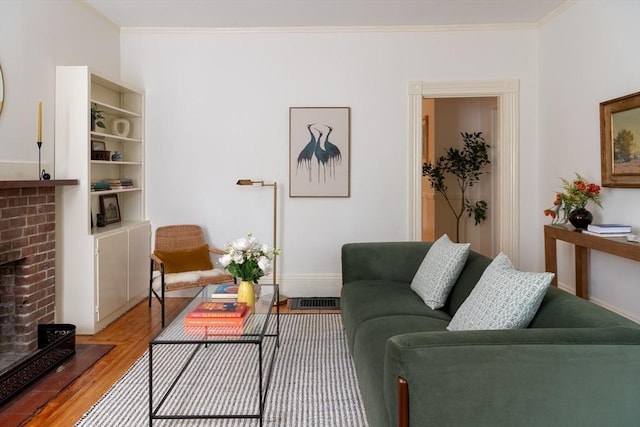24 Foster St, Cambridge, MA 02138 - living room with light wood-type flooring, a brick fireplace, and ornamental molding