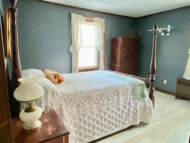 bedroom with ornamental molding, wood-type flooring, and radiator heating unit