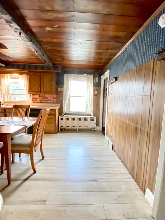 hallway with radiator, wooden walls, wooden ceiling, and light wood-type flooring