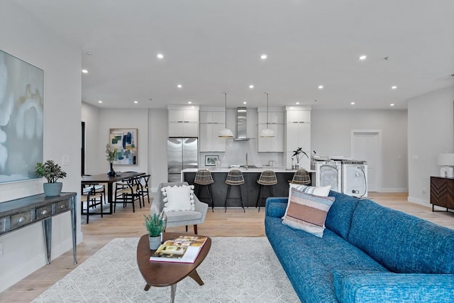 living room with light hardwood / wood-style floors and sink