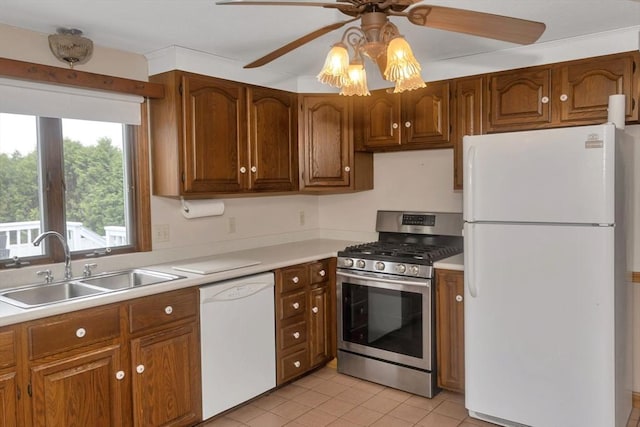 kitchen with white appliances, ceiling fan, a sink, light countertops, and brown cabinets