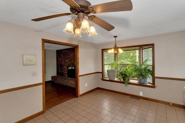 unfurnished room with a ceiling fan, baseboards, and a fireplace
