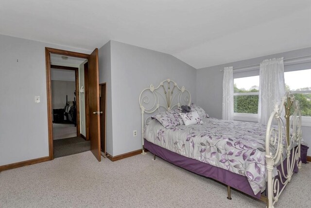 bedroom featuring carpet, vaulted ceiling, and baseboards