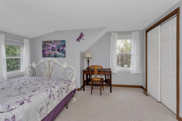 bedroom featuring lofted ceiling, light carpet, multiple windows, and a closet