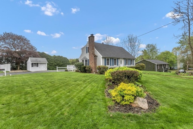 view of side of home with a storage shed, an outdoor structure, a chimney, and a yard
