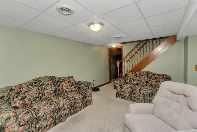 carpeted living room with a paneled ceiling, stairway, and baseboards