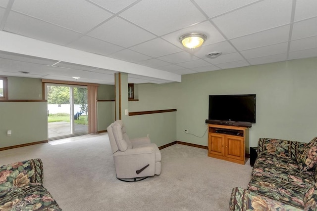 living area with a paneled ceiling, light colored carpet, and baseboards