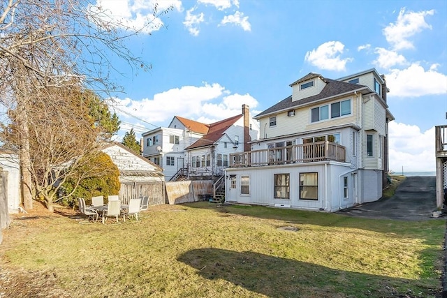 rear view of house with a wooden deck and a yard