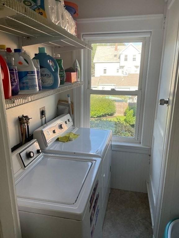 clothes washing area featuring plenty of natural light and washing machine and clothes dryer