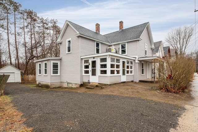 back of house featuring a garage and an outdoor structure