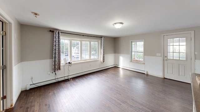 unfurnished room featuring baseboard heating and dark wood-type flooring