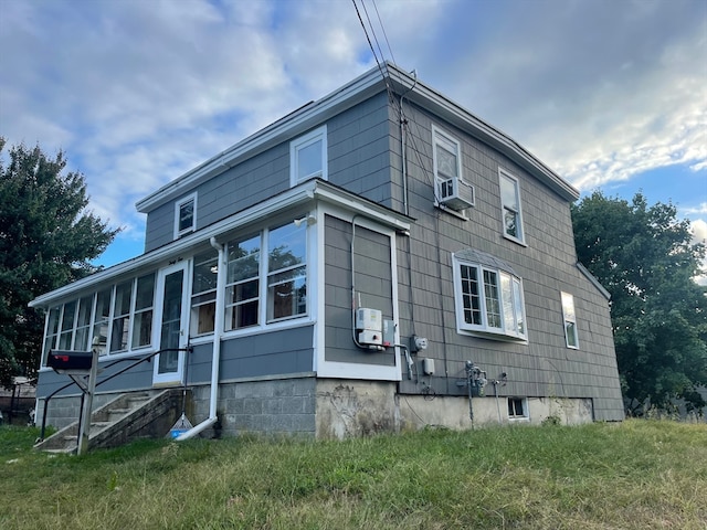 view of side of home with a sunroom and cooling unit