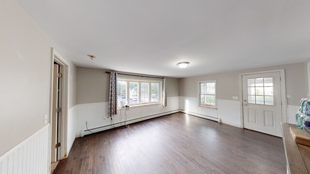 empty room with dark hardwood / wood-style flooring and a baseboard radiator