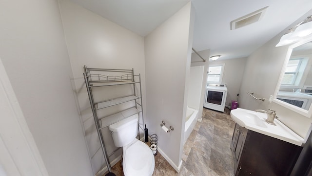 bathroom featuring washer / clothes dryer, vanity, and toilet