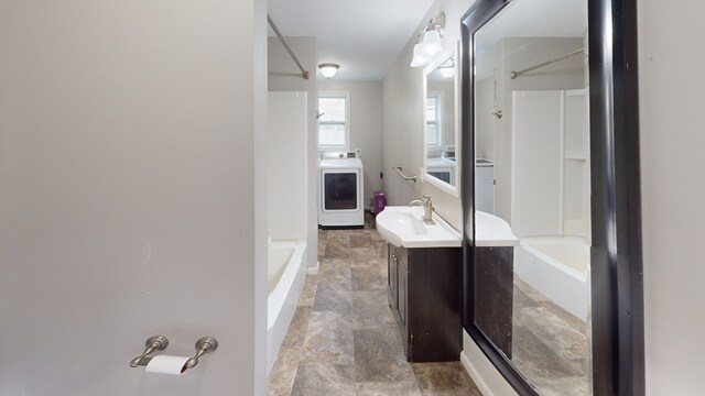 bathroom featuring washer / clothes dryer, vanity, and a bathing tub