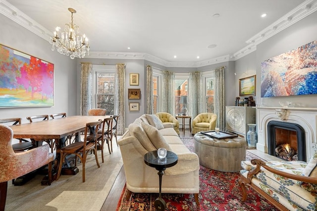 living area featuring light hardwood / wood-style floors, ornamental molding, plenty of natural light, and an inviting chandelier