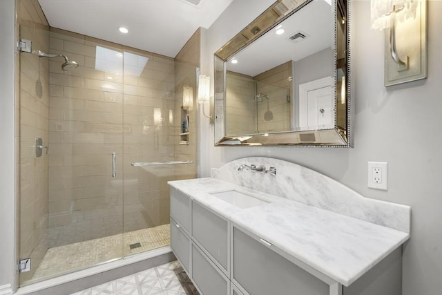 bathroom featuring a shower with door and vanity