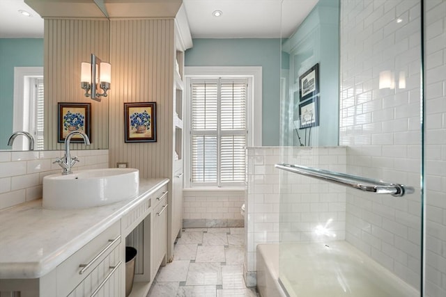 bathroom featuring vanity, a tub to relax in, and tasteful backsplash