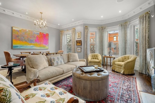 living room with a baseboard radiator, wood-type flooring, crown molding, and a notable chandelier