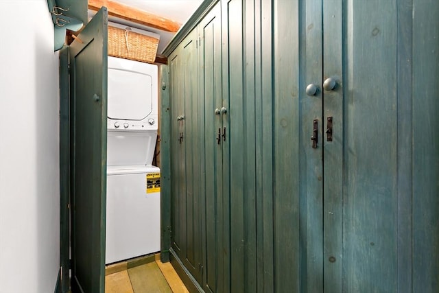 laundry area with laundry area, light wood-style flooring, and stacked washer / dryer