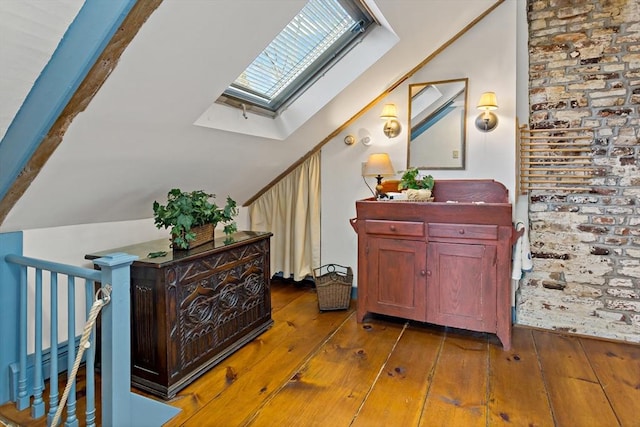 hall featuring lofted ceiling with skylight and hardwood / wood-style flooring