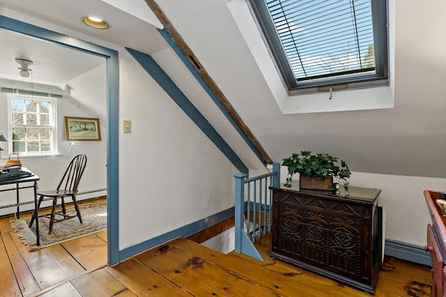 staircase featuring a baseboard heating unit, baseboard heating, vaulted ceiling, and hardwood / wood-style floors