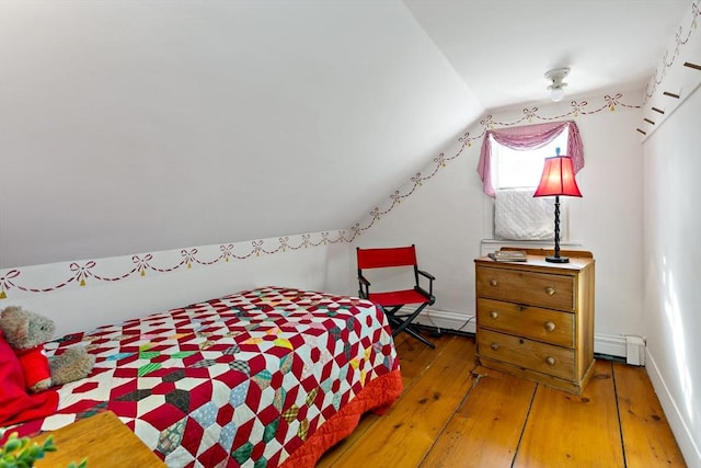 bedroom with lofted ceiling, baseboards, and hardwood / wood-style floors