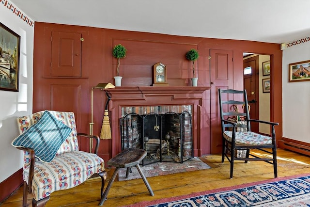 living area featuring wood-type flooring and a fireplace