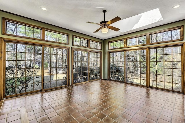 unfurnished sunroom with a skylight and a ceiling fan