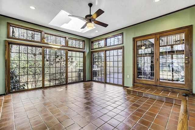 empty room featuring dark tile patterned floors, ceiling fan, and ornamental molding