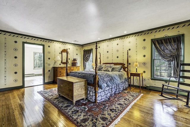 bedroom with hardwood / wood-style floors, crown molding, baseboards, and baseboard heating