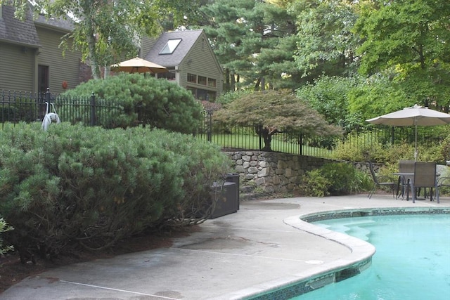 view of swimming pool featuring a fenced in pool, fence, and a patio area