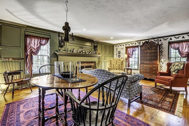 dining room with plenty of natural light, a textured ceiling, and wood finished floors