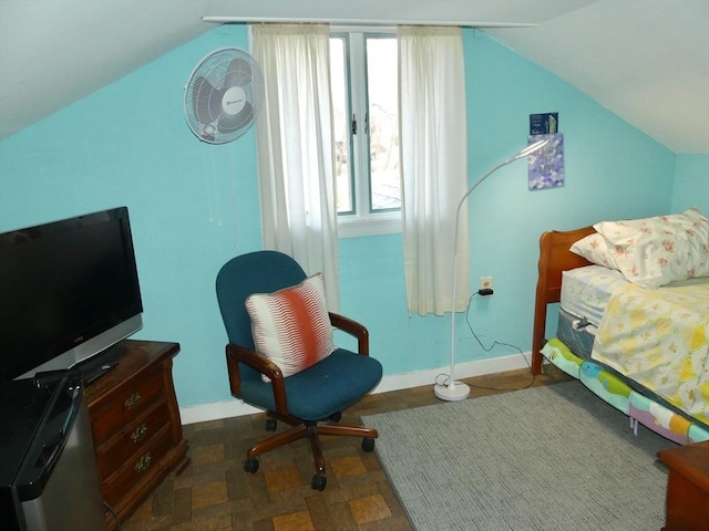 bedroom with vaulted ceiling and multiple windows