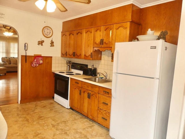 kitchen with ceiling fan, sink, backsplash, white appliances, and ornamental molding