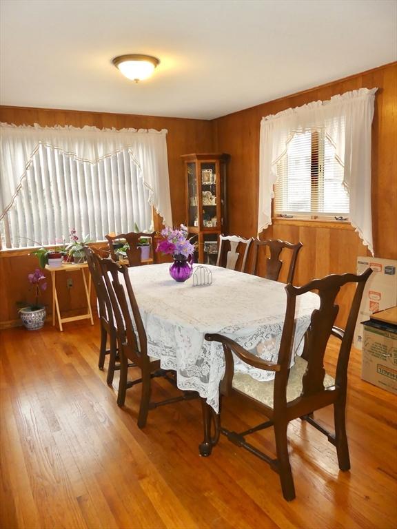 dining area with wood walls and hardwood / wood-style floors