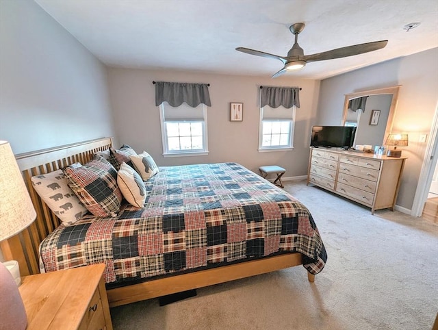 bedroom featuring light colored carpet, ceiling fan, and baseboards