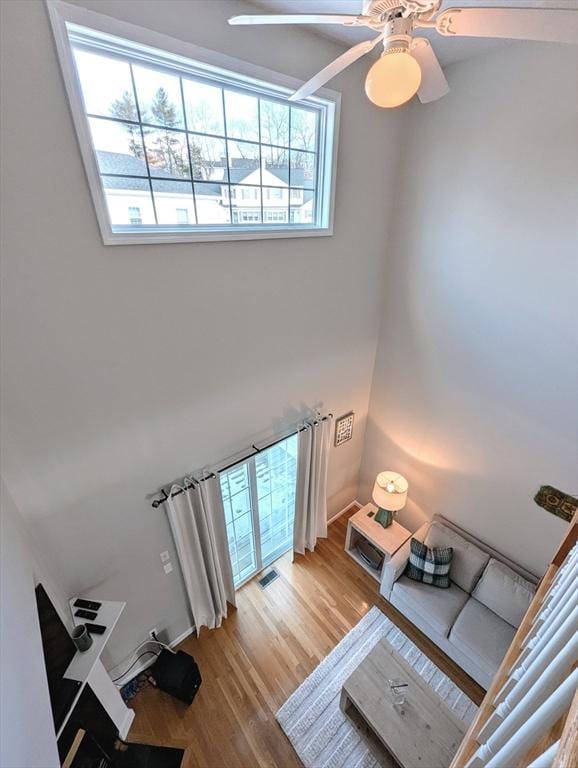 living room featuring wood finished floors, visible vents, and a ceiling fan