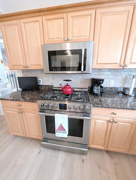 kitchen featuring stainless steel appliances, light brown cabinetry, and light wood-style floors