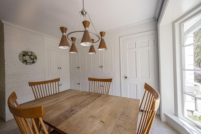 dining room with ornamental molding and brick wall