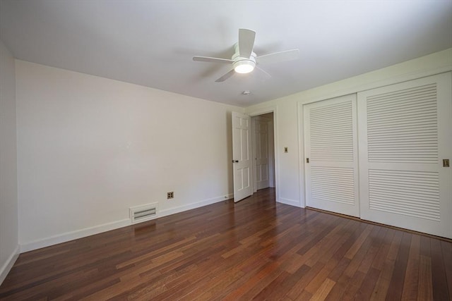 unfurnished bedroom featuring dark wood finished floors, baseboards, a closet, and ceiling fan