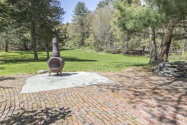 view of patio / terrace with a fire pit and a wooded view