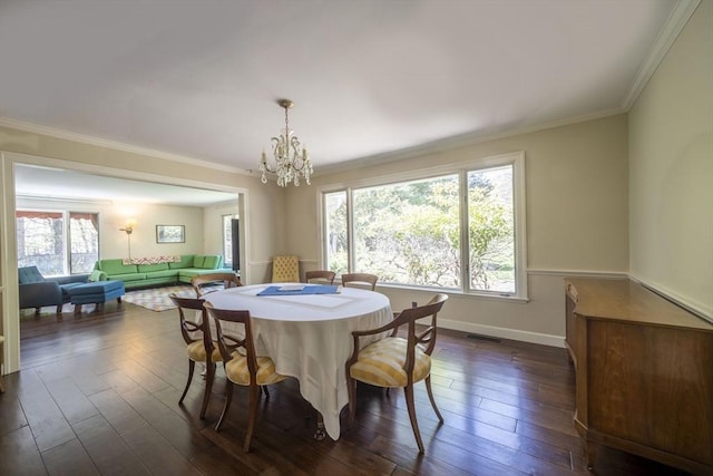 dining room with plenty of natural light, a chandelier, dark wood finished floors, and crown molding