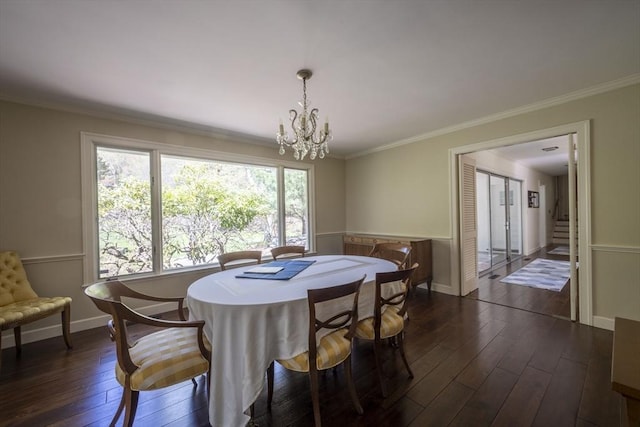 dining room featuring dark wood-type flooring, a chandelier, crown molding, and baseboards