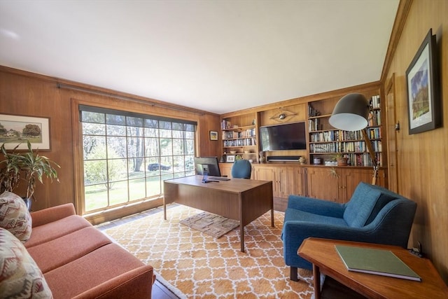 office featuring wooden walls, ornamental molding, and built in shelves