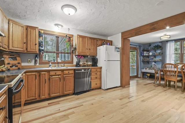 kitchen featuring dishwasher, white refrigerator, sink, range with electric cooktop, and light wood-type flooring