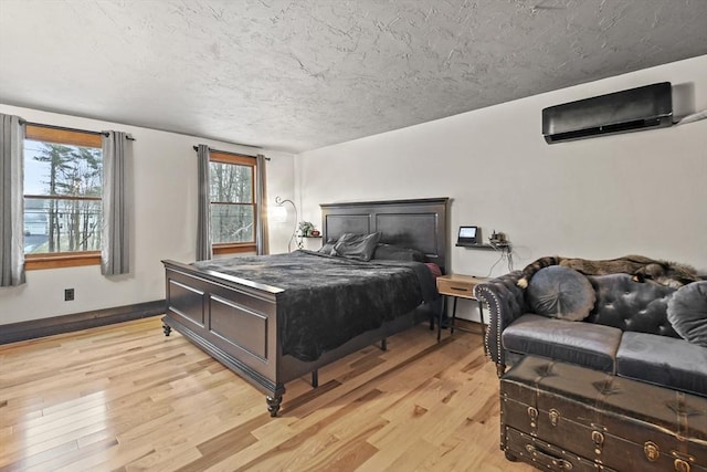 bedroom featuring light hardwood / wood-style floors and a wall mounted AC